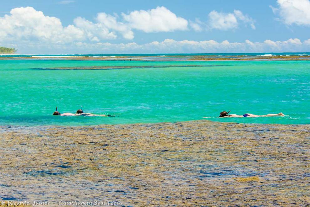 Imagem de um dia maravilhoso com pessoas nadando nas piscinas naturais da Praia Taipu de Fora.